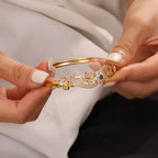 legant Golden-Tone Butterfly Open Bangle Bracelet with Sparkling Synthetic Zirconia & Floral Design.